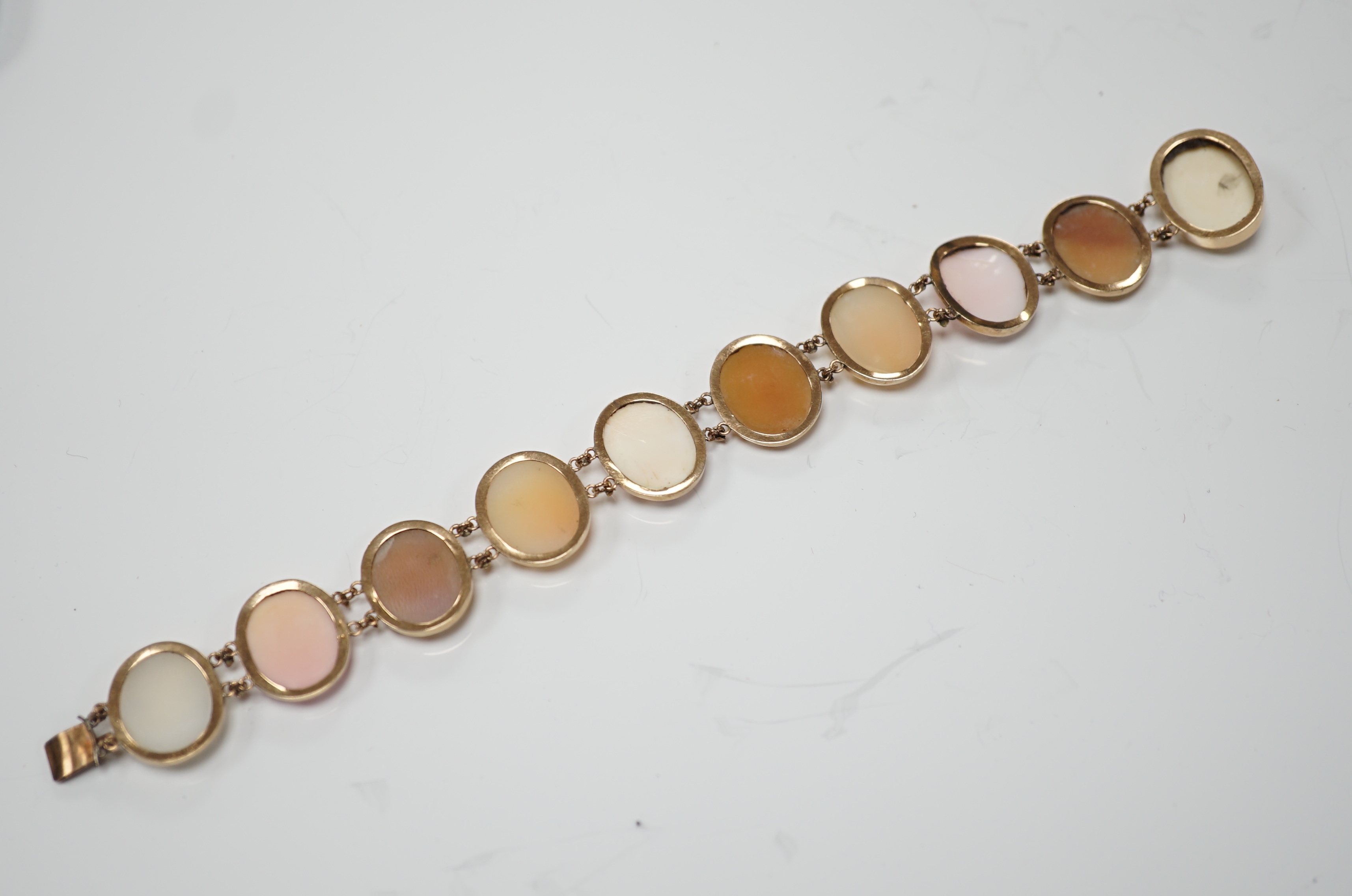 A yellow metal mounted ten stone oval cameo shell set bracelet, each carved with bust of a lady to sinister, 16cm, gross weight 13.9 grams.